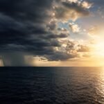 Vista aérea do Oceano Pacífico com contraste entre nuvens de tempestade e áreas ensolaradas, representando as variações climáticas.